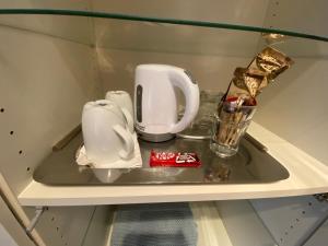 a shelf with cups and dishes on it at Lovely bright double room-private bathroom in London