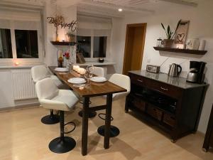 a kitchen with a wooden table and white chairs at Gästewohnung Herbsleben in Herbsleben