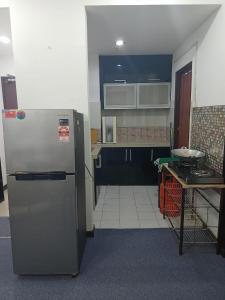 uma cozinha com um frigorífico e uma mesa em NUR MUHAMMAD HOMESTAY em Kubang Kerian