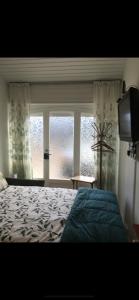 1 dormitorio con cama, ventana y TV en Studio Jeanine en Le Portel