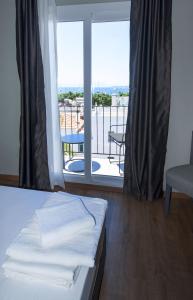 a bedroom with a bed and a view of a balcony at Bodrum Smart City Hotel in Bodrum City