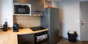 una pequeña cocina con encimera y nevera en Résidence Hermès Paris Orly Aéroport en Villeneuve-le-Roi