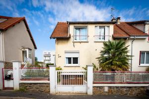 ヴィルヌーヴ・ル・ロワにあるRésidence Hermès Paris Orly Aéroportの白柵と椰子の木のある家