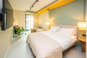 ein Schlafzimmer mit einem großen weißen Bett in einem Zimmer in der Unterkunft Design Rooms - Kvaternik Square in Zagreb
