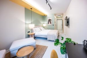 ein Schlafzimmer mit einem Bett, einem Tisch und einer Couch in der Unterkunft Design Rooms - Kvaternik Square in Zagreb