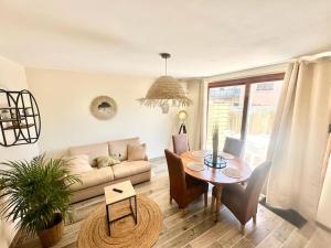a living room with a table and a couch at L'Evasion - Climatisé - Jardin - Plage - Jacuzzi in Perpignan