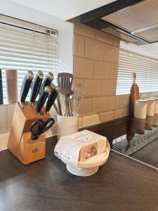 a kitchen counter with a box of utensils and a knife block at Wild Olive 65 Farmhouse Style in Windhoek