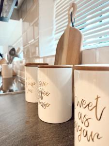 three cups sitting on a counter with writing on them at Wild Olive 65 Farmhouse Style in Windhoek