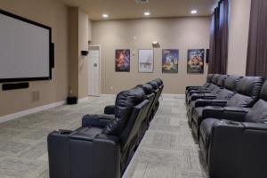 a waiting room with leather chairs and a projection screen at Heated Pool Vacation Villa, Theme Room, Gated Community near Disney, Sleeps 12! in Kissimmee