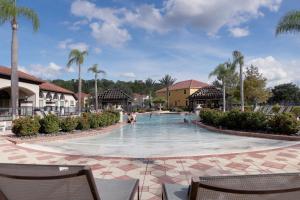 uma piscina num resort com palmeiras em Heated Pool Vacation Villa, Theme Room, Gated Community near Disney, Sleeps 12! em Kissimmee