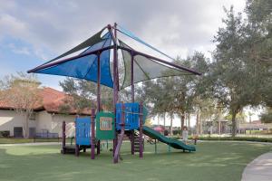 um parque infantil com cadeiras azuis e um escorrega em Heated Pool Vacation Villa, Theme Room, Gated Community near Disney, Sleeps 12! em Kissimmee
