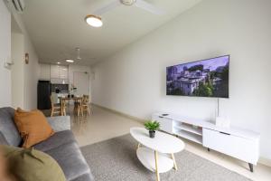 een woonkamer met een bank en een tv aan de muur bij Beautiful 3B2B for 6 pax w Pool - Setapak in Kuala Lumpur