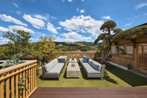 a patio with couches and a table on a deck at Hotel New Wakasa in Nara