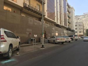 un grupo de coches estacionados al lado de una calle en جوار البيت مكة en La Meca