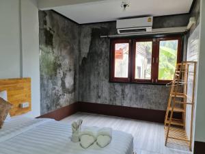 a bedroom with a bed with two hearts on it at Mookboonchu Guesthouse ,Kohmook Trang in Koh Mook