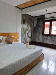une chambre dotée d'un lit avec un chat rembourré. dans l'établissement Mookboonchu Guesthouse ,Kohmook Trang, à Ko Muk