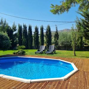 a swimming pool in a yard with two chairs at Villa Vigneto 