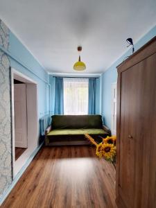 - une chambre avec un lit dans une pièce bleue dotée d'une fenêtre dans l'établissement Domek przy Maja, à Milicz