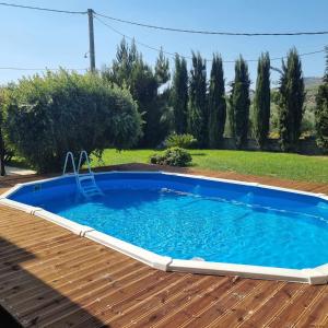 a small blue swimming pool on a wooden deck at Villa Vigneto 