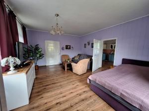 a bedroom with a bed and a living room at Domek przy Maja in Milicz
