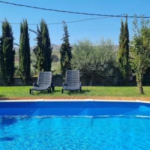 a pair of chairs sitting next to a swimming pool at Villa Vigneto 