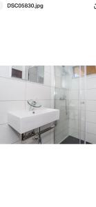 uma casa de banho branca com um lavatório e um chuveiro em Faustina's place em Portimão