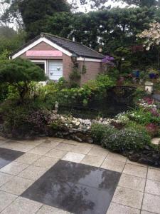 a house with a garden of flowers and plants at Romantisch Tiny Gardenhouse in beautiful garden in Zandvoort