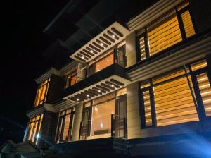 a large building with illuminated windows at night at Uptown Boutique Home - 2BHK with drive-in in Shimla