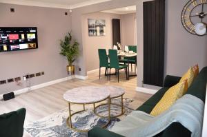 Modern 3 bedroom house- 2 parking spaces- near central MK في Shenley Lodge: غرفة معيشة مع أريكة وطاولة