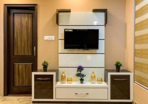a living room with a tv on a wall at Uptown Boutique Home - 2BHK with drive-in in Shimla