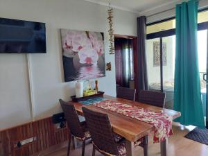 uma sala de jantar com uma mesa de madeira e cadeiras em La Vida Selfcatering Apartements em Mahé
