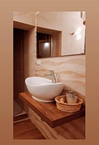 uma casa de banho com um lavatório branco num balcão de madeira em ARAGONESE 73 em Taranto