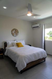 Schlafzimmer mit einem großen Bett und einem Deckenventilator in der Unterkunft Spacious 3BR Home with Own Private Cozy Pool in Koolbaai