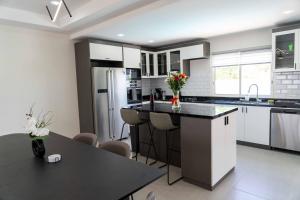 a kitchen with white cabinets and a black counter top at Spacious 3BR Home with Own Private Cozy Pool in Koolbaai