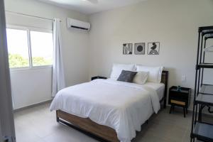 a white bedroom with a large bed and a window at Spacious 3BR Home with Own Private Cozy Pool in Koolbaai