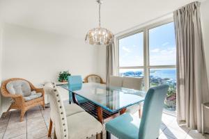 a dining room with a glass table and chairs at Tristan Towers unit 10A in Pensacola