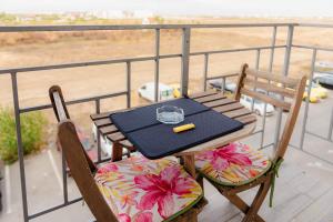 una mesa y sillas con una copa en el balcón en AZUR CYAN HOUSE, en Bucarest