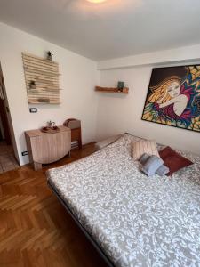 1 dormitorio con 1 cama y una pintura en la pared en Bijoux du Cervin, en Breuil-Cervinia