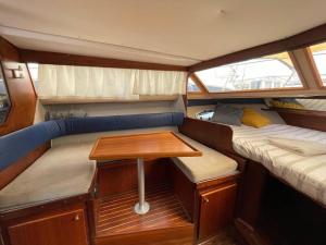 une petite chambre avec une table à l'arrière d'un bateau dans l'établissement Barco acogedor - Cosy Boat - Barcelona, à Barcelone