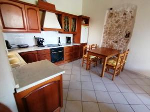 a kitchen with wooden cabinets and a table and chairs at Home of sunset in Rethymno