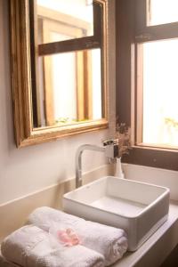 a bathroom with a white sink and a mirror at Lá em Casa - Guest House in Barra Grande