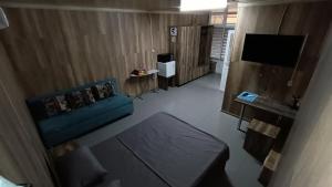 een woonkamer met een blauwe bank en een televisie bij The Mini-hotel on Mukanova St in Alma-Ata