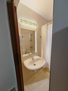 a bathroom with a white sink and a mirror at Cleopetra Hotel in Wadi Musa