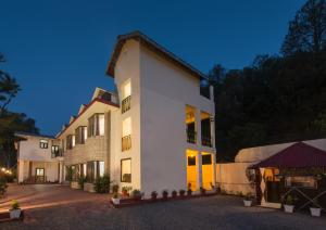 a large white building with its lights on at IVY The Boutique Hotel By Sukhmani Resorts in Nainital