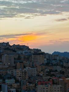 un perfil urbano con una puesta de sol en el fondo en Cleopetra Hotel, en Wadi Musa