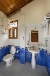 a blue and white bathroom with a toilet and a sink at IVY The Boutique Hotel By Sukhmani Resorts in Nainital