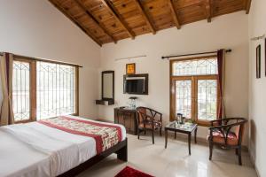 a bedroom with a bed and a table and chairs at IVY The Boutique Hotel By Sukhmani Resorts in Nainital