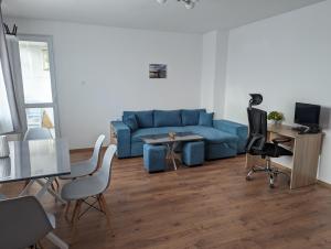 ein Wohnzimmer mit einem blauen Sofa und einem Tisch in der Unterkunft Teo's place in Ruse