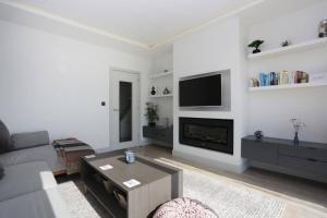 een woonkamer met een bank en een tv bij BOURNECOAST: 3 BED-SEA VIEWS/BALCONY/GARDEN-HB6314 in Southbourne