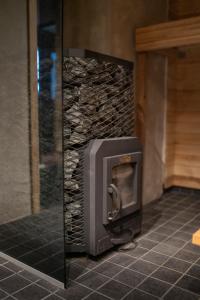 a fireplace in a room with a stone wall at Peetri talu klaaskuplid Haapsalu lähedal in Rootsi